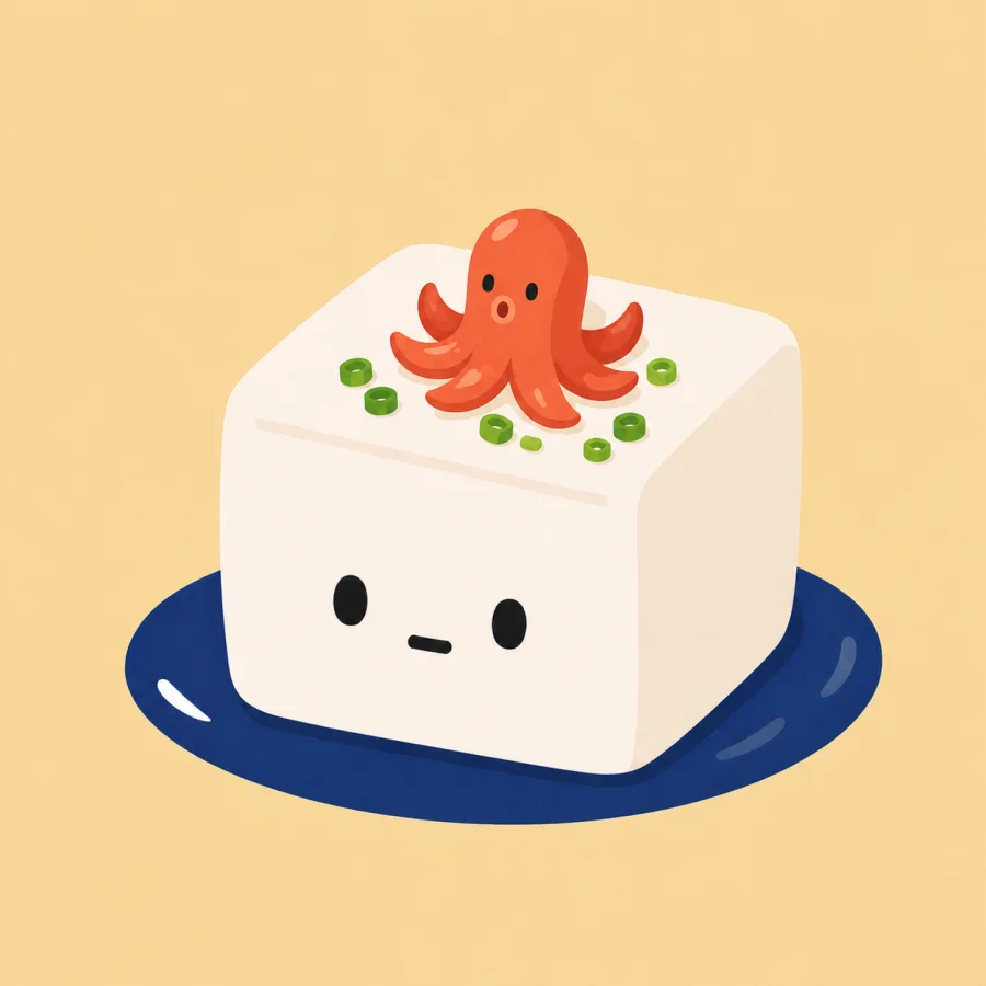 A cute tofu character on a navy plate with shiso and sesame.